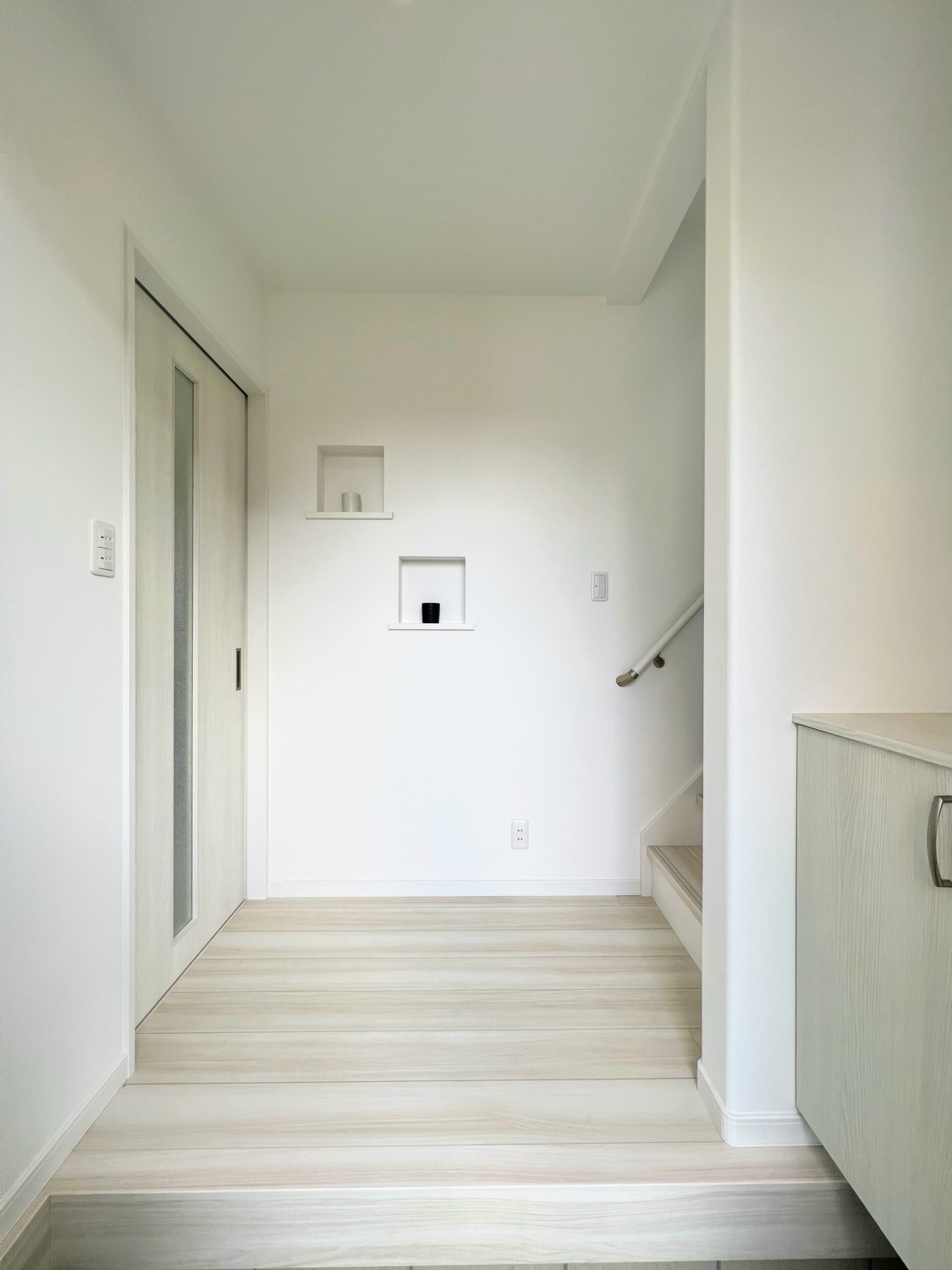 部屋全体がすっきりとして見える白を基調とした、空間の効率的な活用と充実した収納があるシンプルモダンスタイルの家
