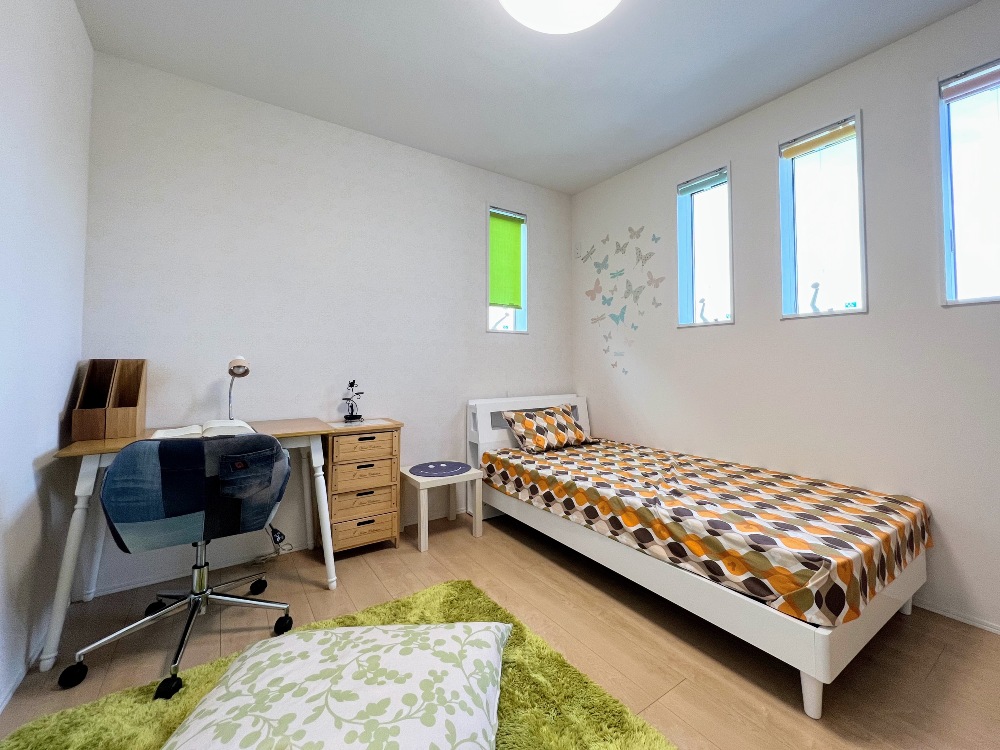 カーテンがカラフルなこども部屋。縦すべりの窓で風通しも良くなります。